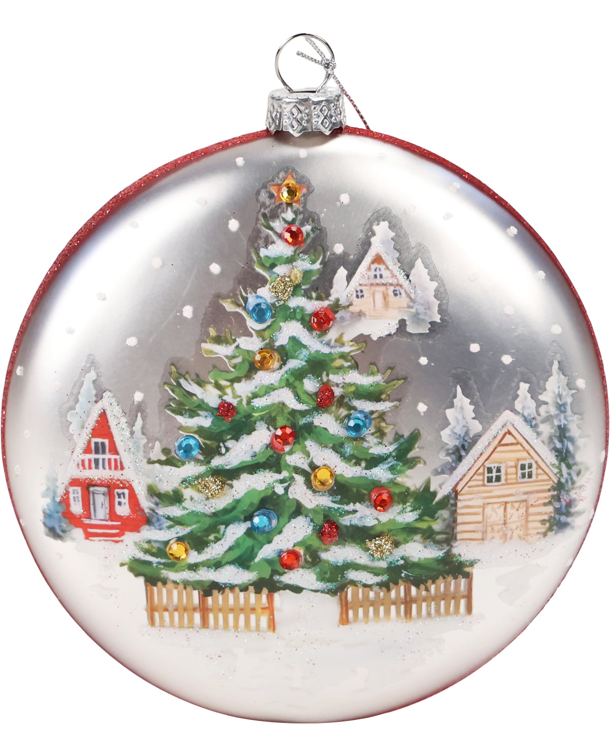 A round glass Christmas ornament featuring a hand-painted winter village scene with a snow-covered green Christmas tree, colorful ornaments, and small cabins under a snowy sky.