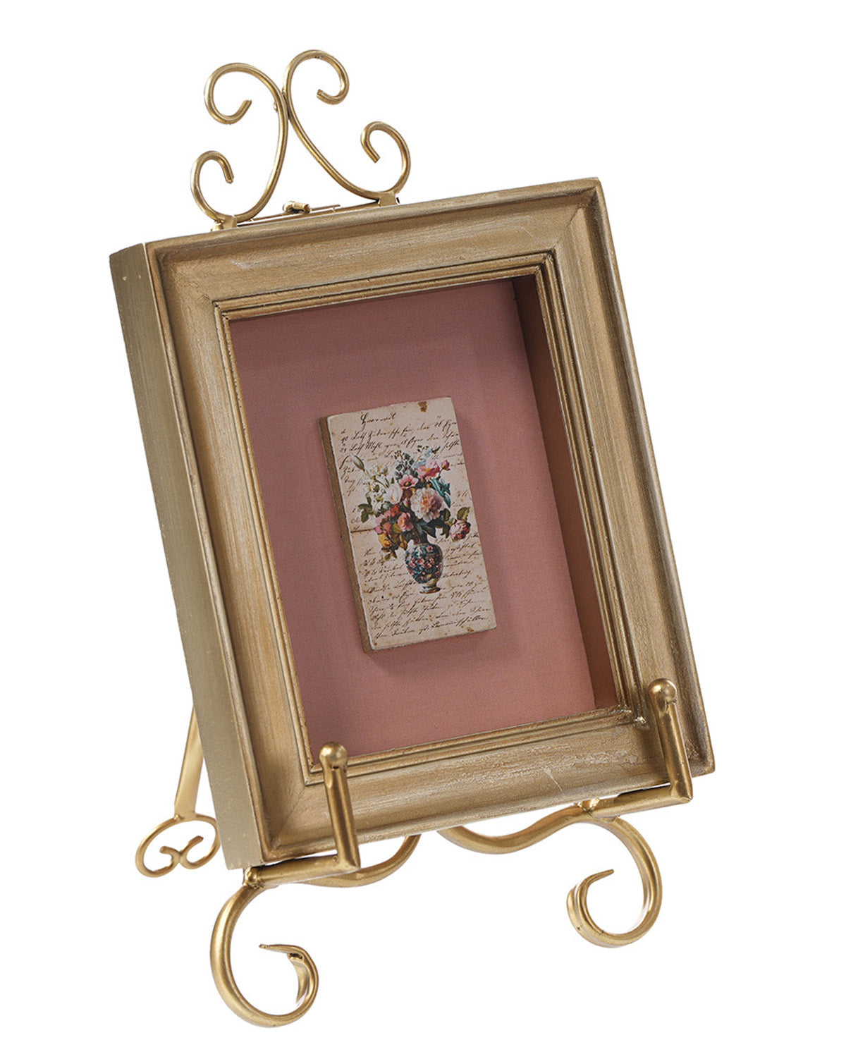 A small decorative picture frame with a distressed gold finish and ornate scroll feet, holding a vintage floral postcard on a dusty pink background.