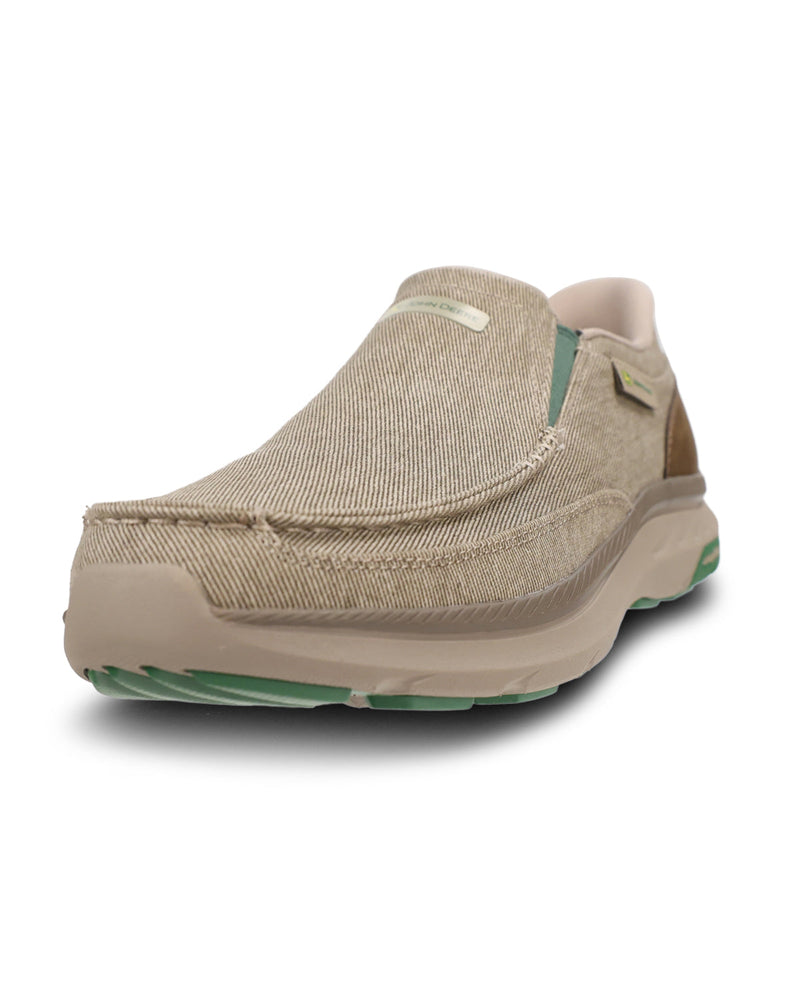 A single slip-on shoe in a textured beige fabric upper with a thick beige sole and light green accents on the midsole and outsole, shown against a plain white background.