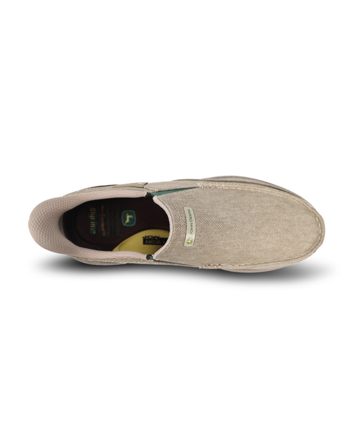 A single slip-on shoe shown from a top-down view on a white background. The shoe has a light beige canvas upper, a dark brown interior lining, and a small green and white side label.