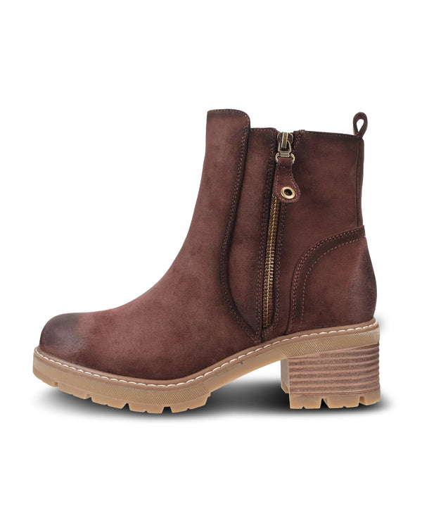A brown suede ankle boot with a side zipper, a chunky stacked lug sole, and a light tan block heel, shown from a side profile on a white background.