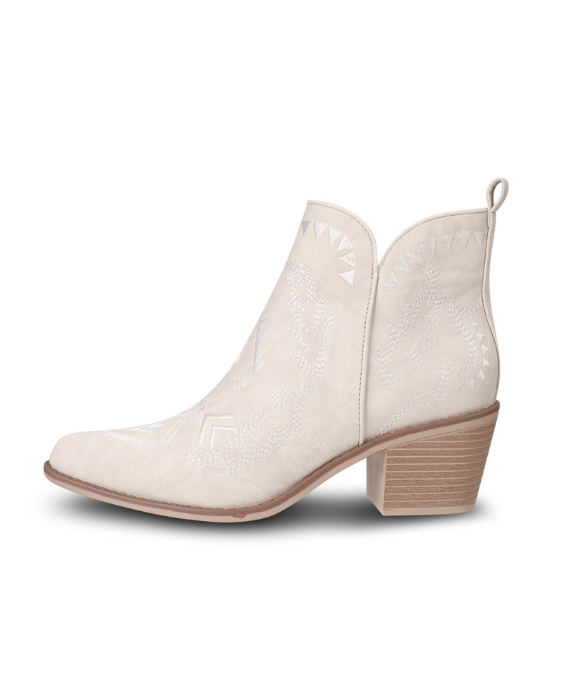 A single light beige western-style ankle boot with a pointed toe, embossed geometric pattern, and a stacked block heel, shown against a plain white background.