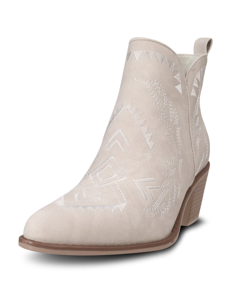 A light beige western-style ankle boot with white embroidered geometric patterns, a pointed toe, and a low brown block heel, shown on a white background.