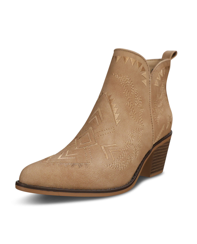 A light tan suede ankle boot with a low stacked heel and embossed geometric western-style stitching, shown from a three-quarters angle on a white background.