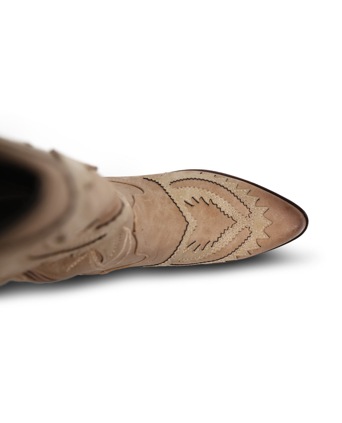 A close-up side view of a light tan suede western boot with decorative contrast stitching and a pointed toe, shown against a plain white background.