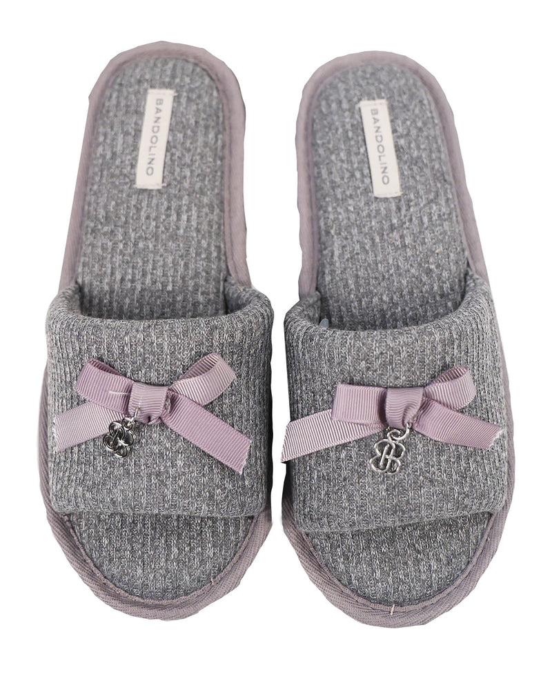 Pair of gray slippers with purple bows and a brand label on a white background