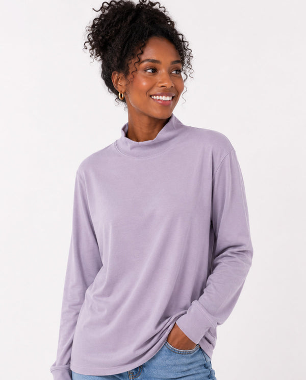 Woman wearing a light purple long-sleeve top on a white background