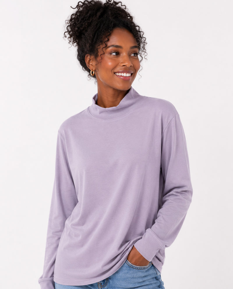 Woman wearing a light purple long-sleeve top on a white background