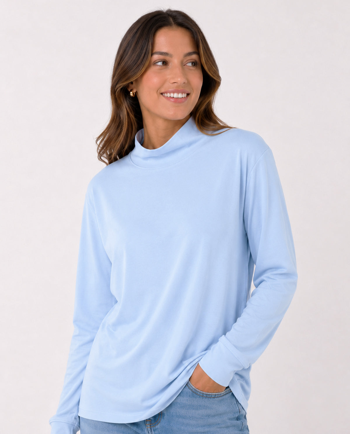 Woman wearing a light blue long-sleeve top against a plain background