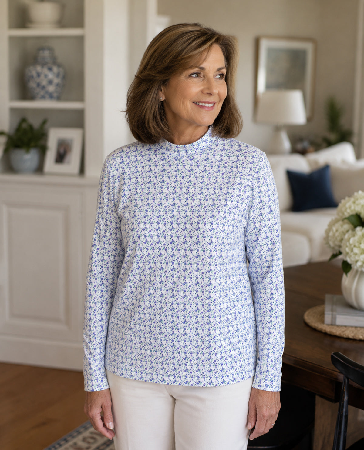 Woman wearing a blue floral long-sleeve shirt in a living room setting