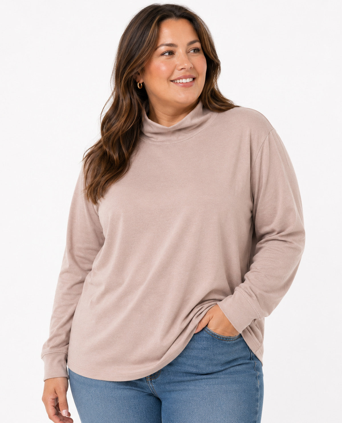 A woman wearing a long-sleeve, high-neck turtleneck top in a dusty rose color, paired with blue jeans, against a plain white background.