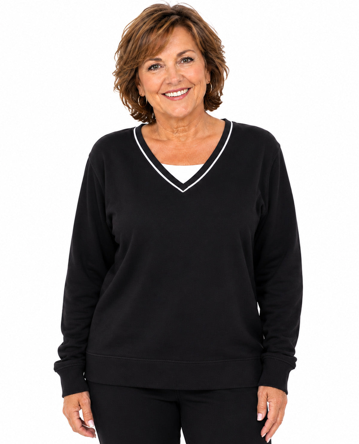 A smiling woman with short brown hair wearing a black long-sleeve V-neck sweatshirt with white trim, layered over a white undershirt, against a plain white background.