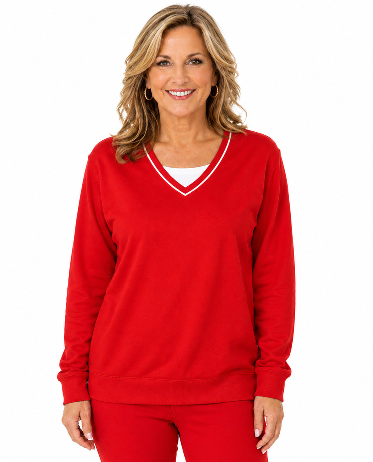 A smiling blonde woman wearing a bright red long-sleeve V-neck sweatshirt with white trim and matching red pants, photographed against a plain white studio background.