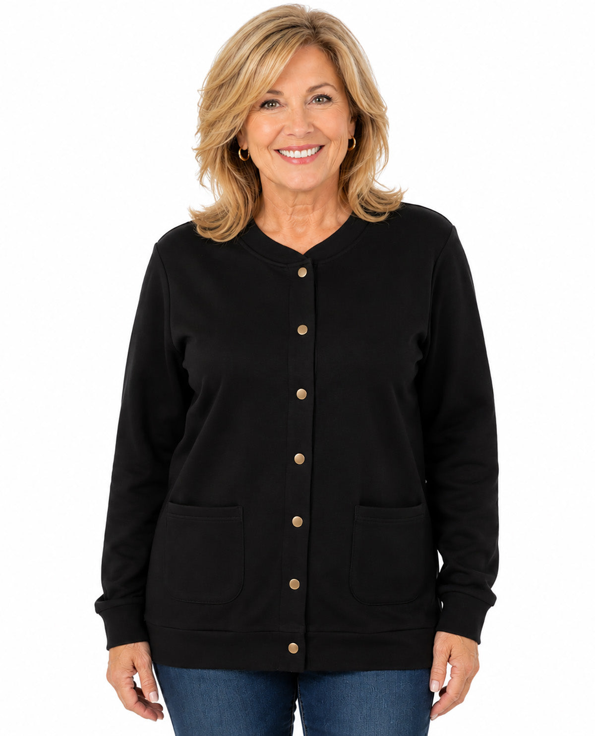 A smiling blonde woman wearing a black long-sleeve button-front cardigan with two front patch pockets and gold-tone buttons, paired with blue jeans, against a plain white background.