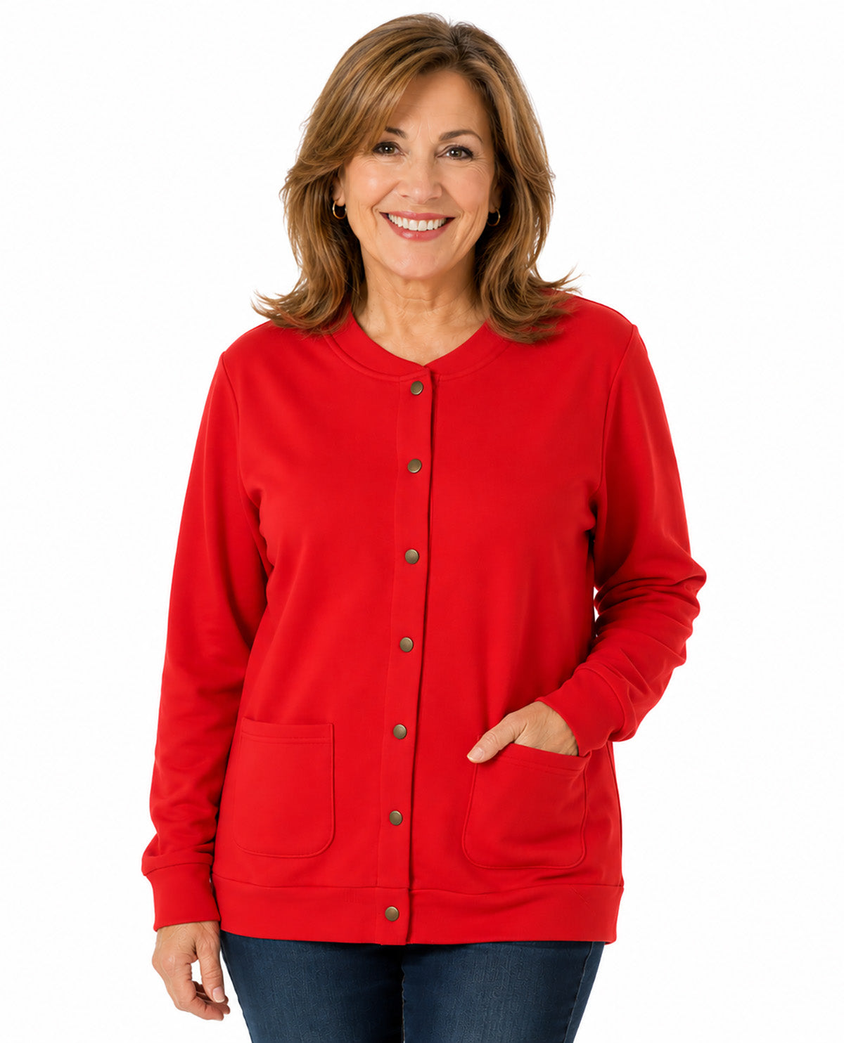 A smiling woman with shoulder-length brown hair wearing a bright red button-front cardigan with front pockets and dark blue jeans, photographed against a plain white studio background.