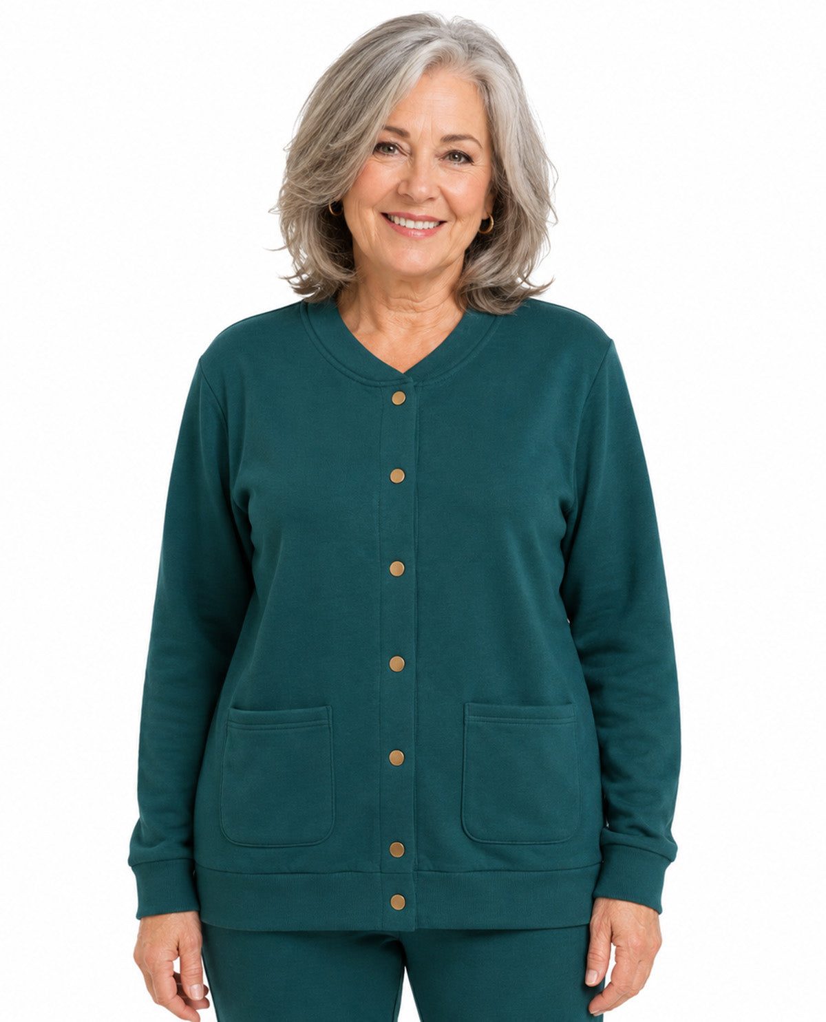 A smiling older woman with gray hair wearing a dark teal green long-sleeve button-front cardigan with two front patch pockets and matching pants, photographed against a plain white background.