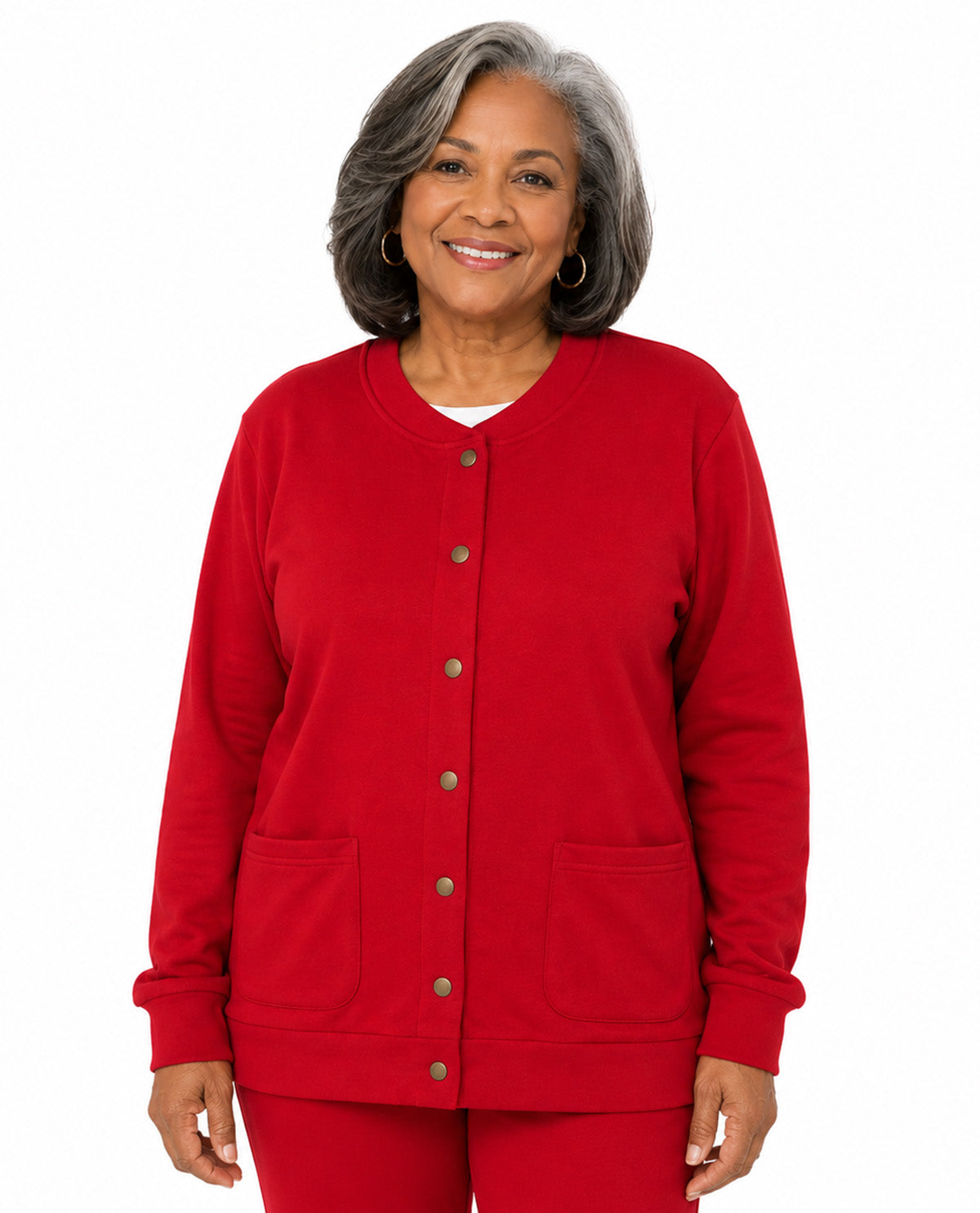 An older woman with gray hair is wearing a bright red button-front cardigan with two front patch pockets and matching red pants, photographed against a plain white background.
