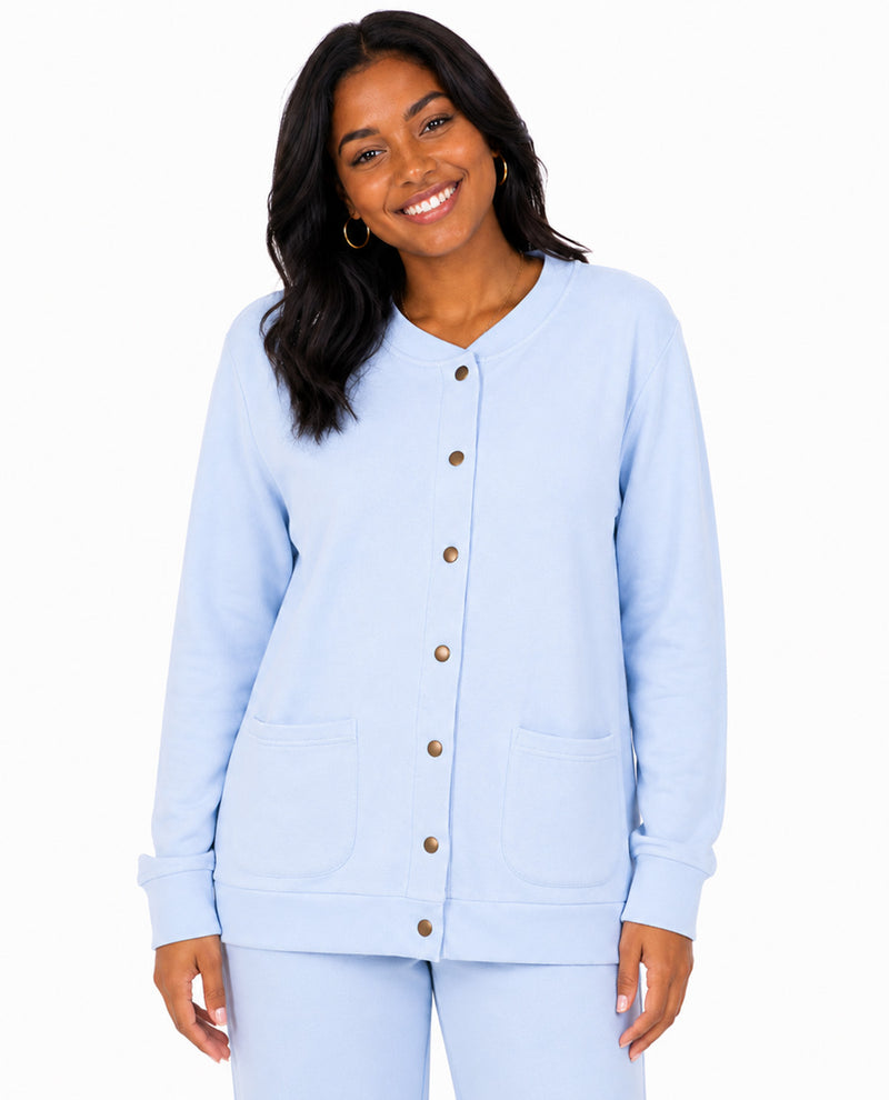 A woman modeling a light blue long-sleeve button-front cardigan with two front patch pockets and matching light blue pants against a plain white background.