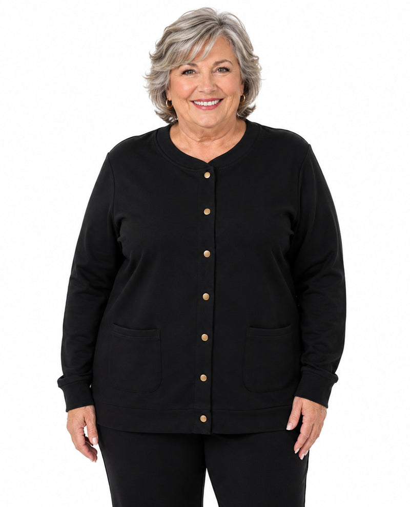 A smiling older woman with short gray hair wearing a black long-sleeve button-front cardigan with two front patch pockets, shown against a plain white studio background.