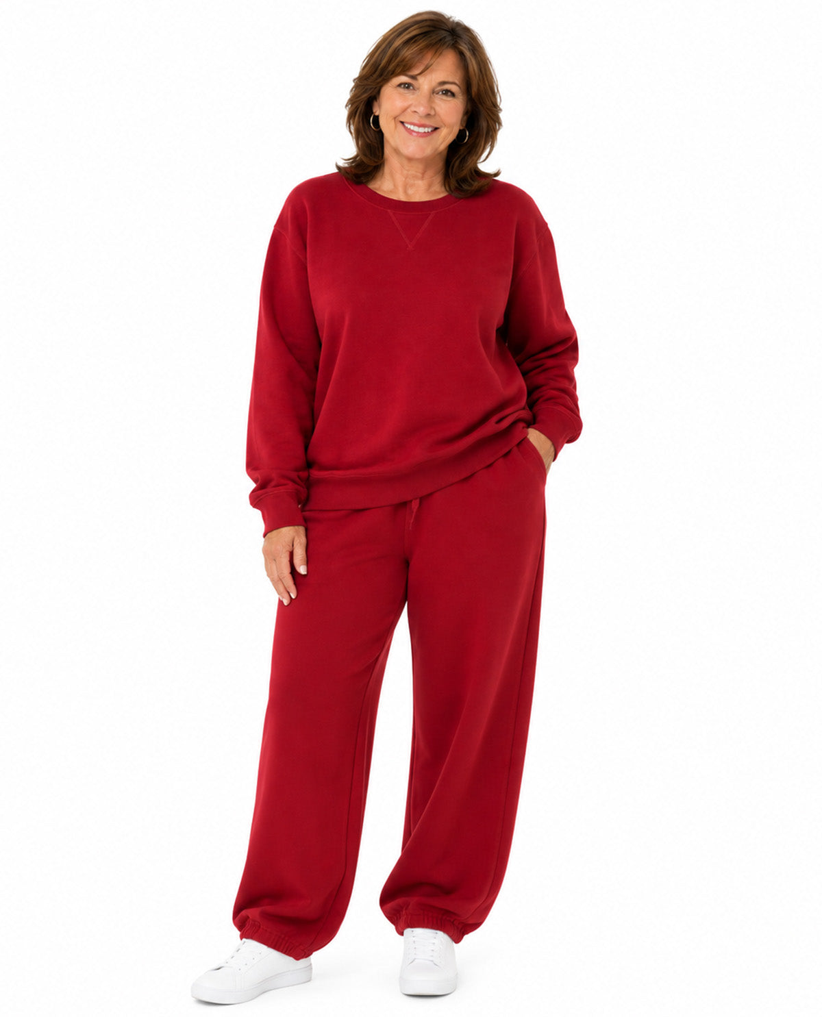A woman modeling a matching red sweatshirt and wide-leg sweatpants lounge set against a plain white background.