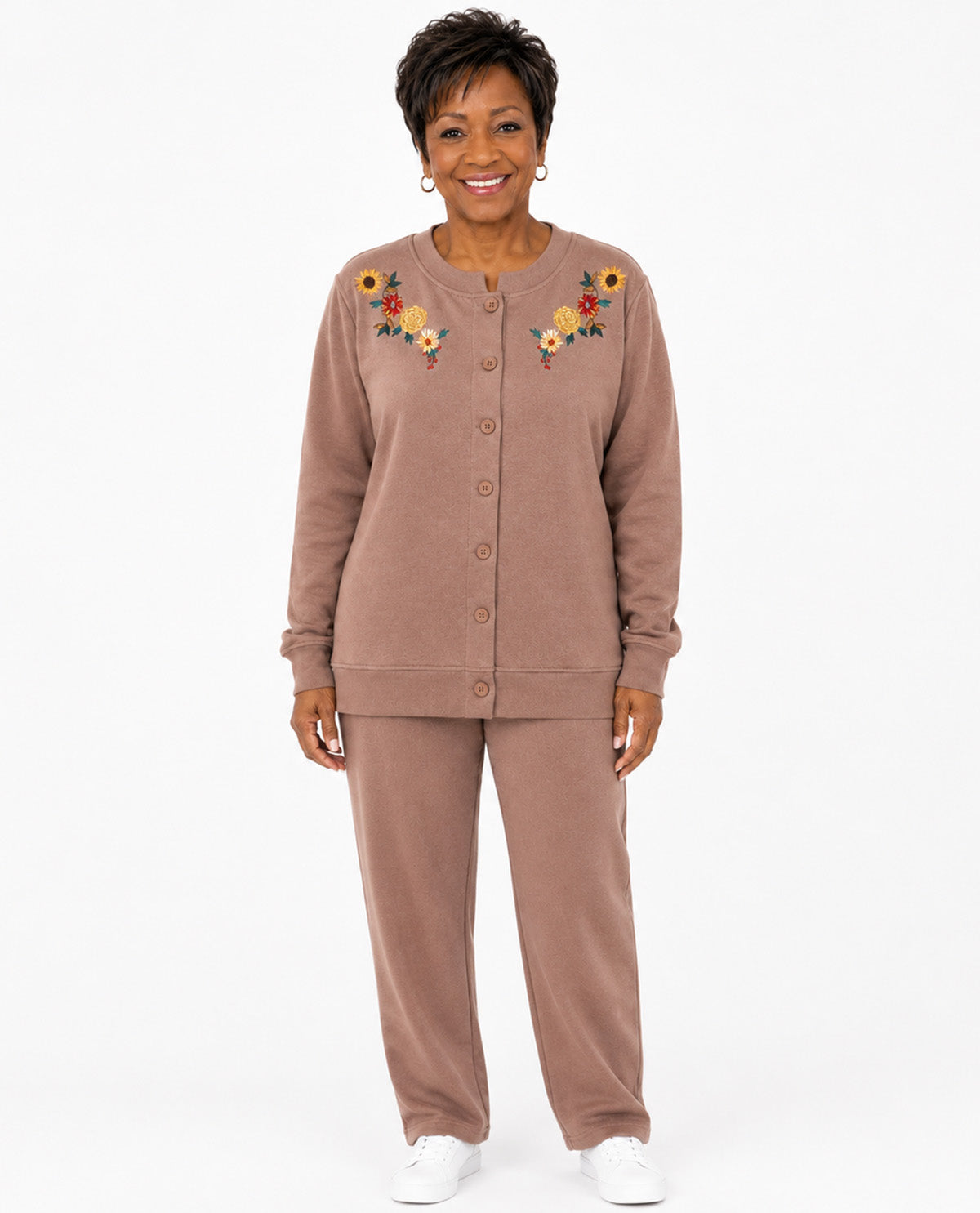 A woman modeling a matching two-piece lounge set in a dusty rose-brown color, featuring a button-front long-sleeve top with colorful floral embroidery on the chest and matching wide-leg pants, against a plain white background.