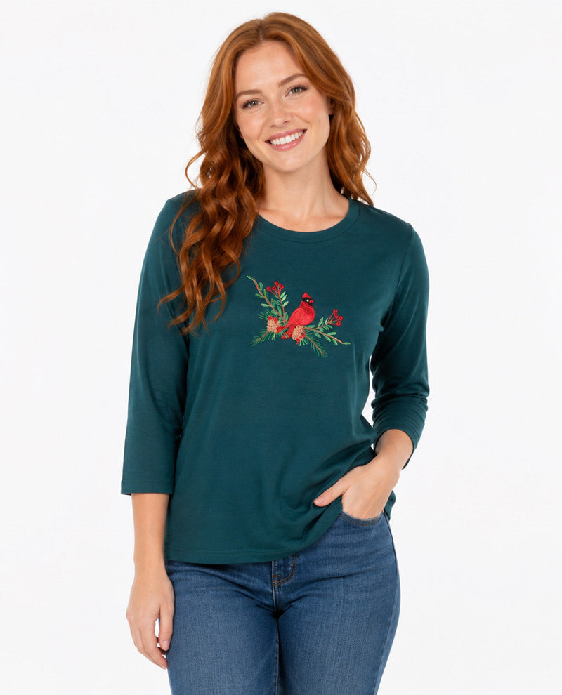 Person wearing a green top with a red bird with a white background