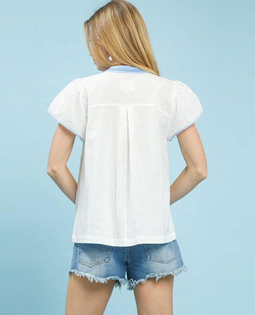 Person wearing a white shirt and denim shorts on a light blue background