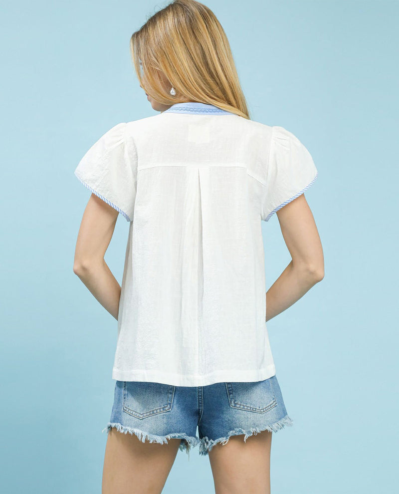 Person wearing a white shirt and denim shorts on a light blue background
