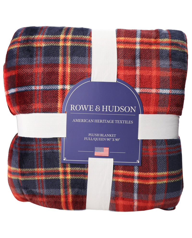 A folded plaid throw blanket with a red, navy, and orange tartan pattern, wrapped in white paper bands with a blue Rowe & Hudson label in the center.