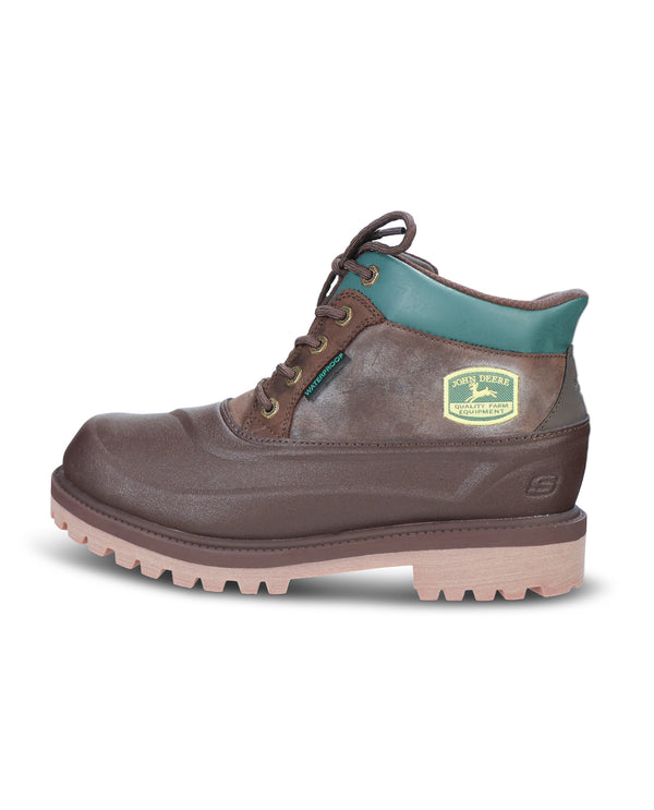 A single brown leather work boot with a teal collar lining, a gold shield logo on the side, and a light beige sole, shown against a plain white background.