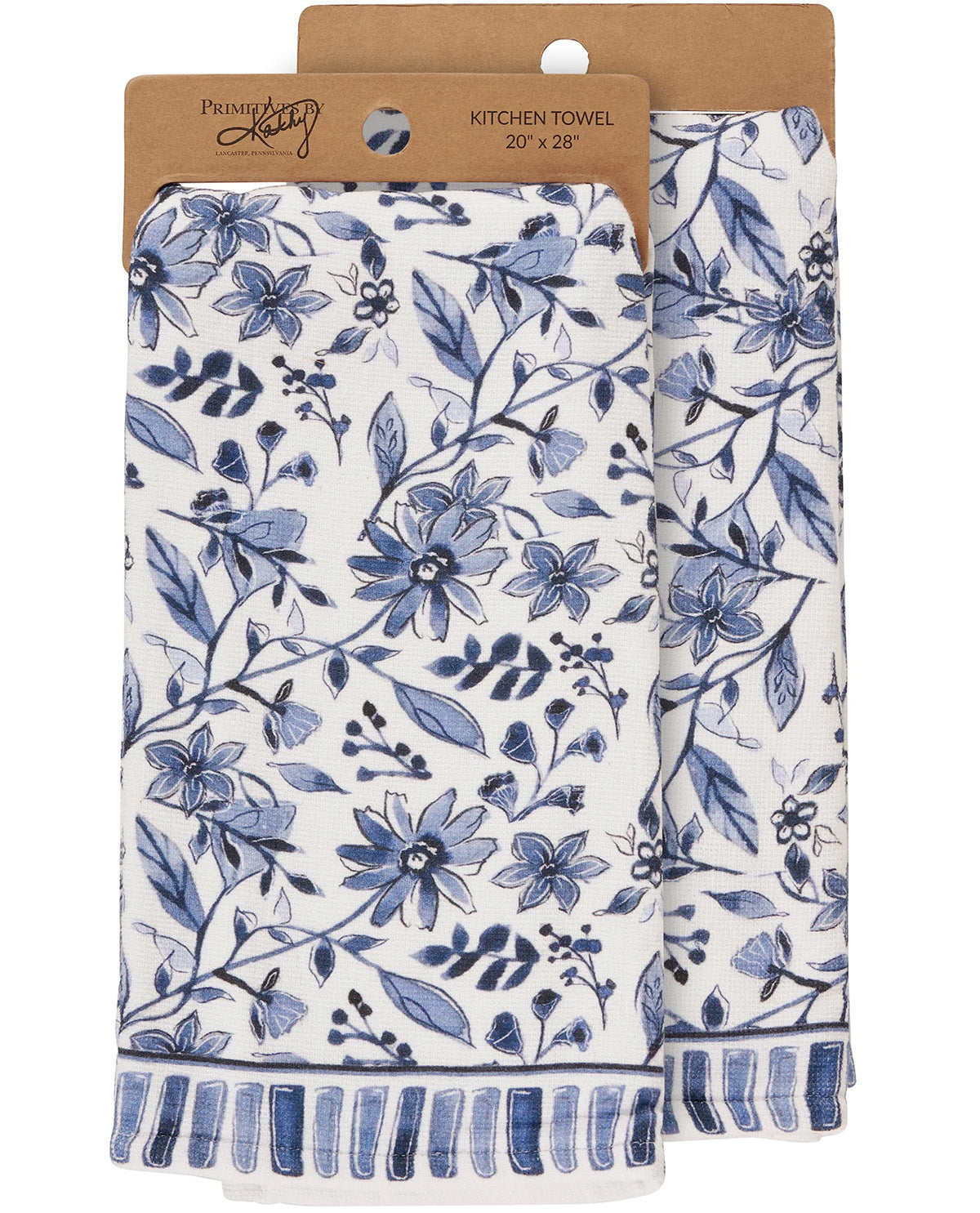Two white kitchen towels with a blue floral pattern and striped fringed edges, hanging from kraft paper hangers labeled Preset by Preset.