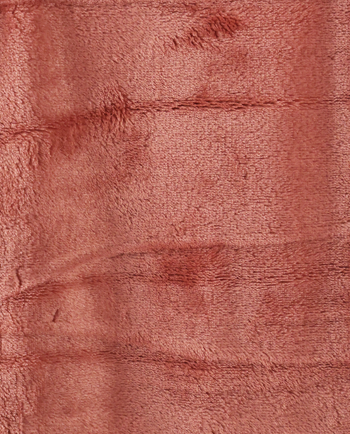 A close-up of a dusty rose pink plush fabric texture with soft horizontal folds.