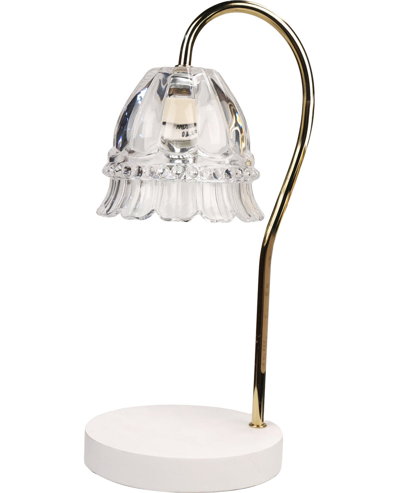Decorative table lamp with clear glass shade and gold arm on a white background