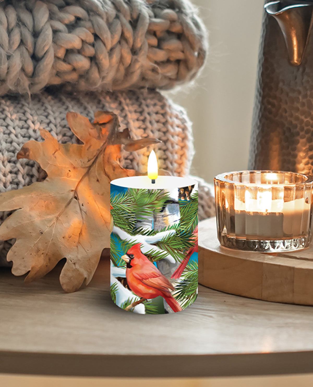 Decorative candle with a bird design on a wooden surface with a cozy background.