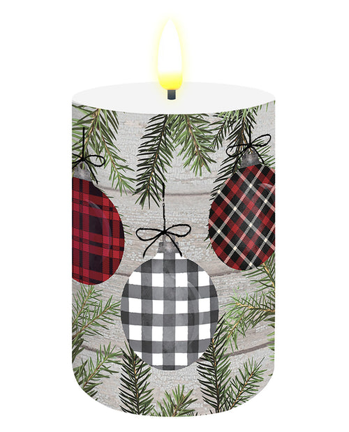 Decorative candle with plaid ornaments and greenery on a white background