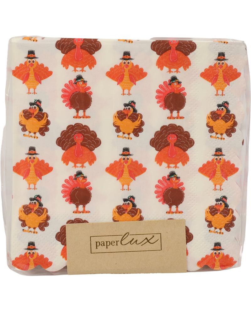 A packaged set of white paper napkins featuring a repeating pattern of cartoon turkeys in orange, brown, and red, with a kraft paper label at the bottom that reads 'paper lux'.