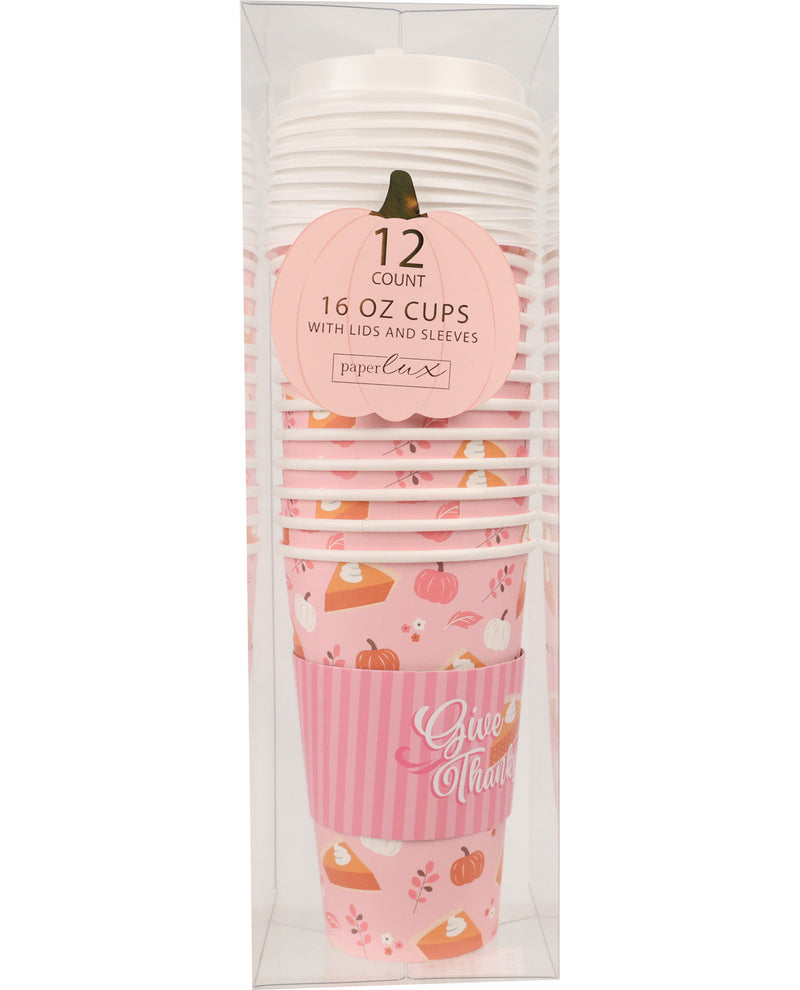 A 12-count stack of Paper Cakes 16 oz cups with lids and sleeves, featuring a fall-themed design with pink stripes, a striped sleeve, and autumn illustrations, packaged in a clear plastic box.