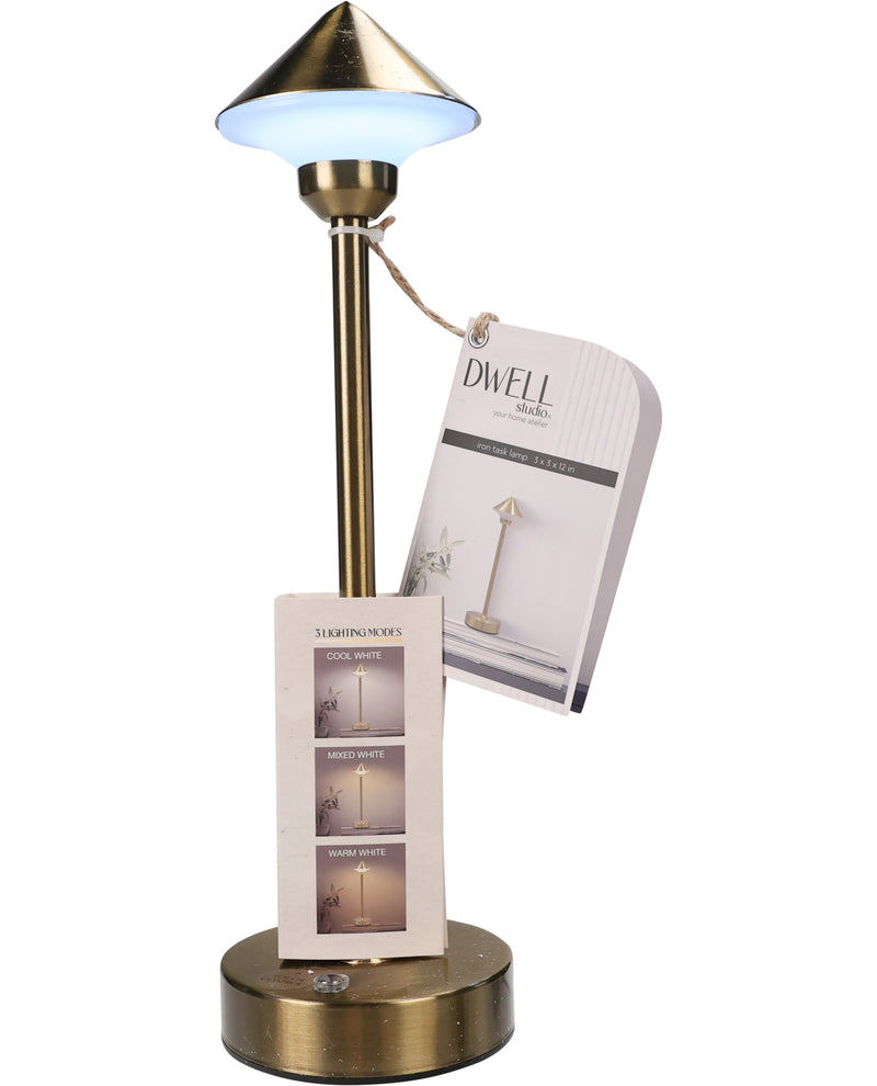A brass table lamp with a conical shade emitting a cool blue-white light, shown with its retail packaging tags against a white background.