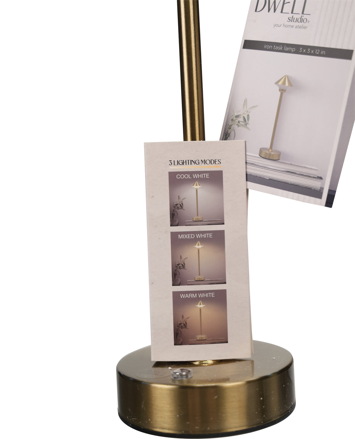 A brass table lamp base and matching lamp pole stand on a white background, with a small card showing lighting mode options and a package insert behind it.