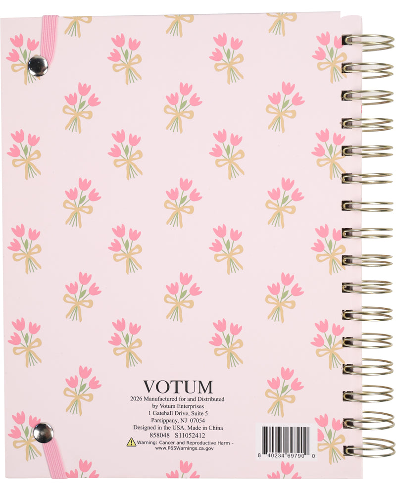 Notebook with floral design and 'Votum' branding on a pink background