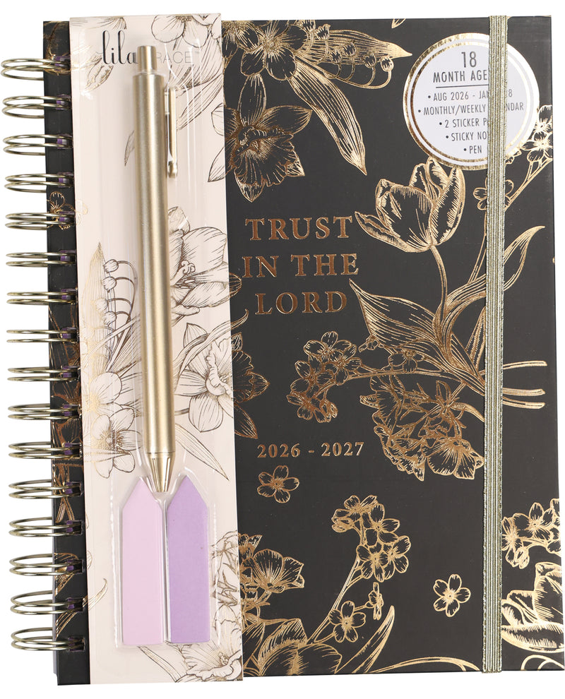 Planner with floral design and 'Trust in the Lord' text, featuring a pen and bookmarks.