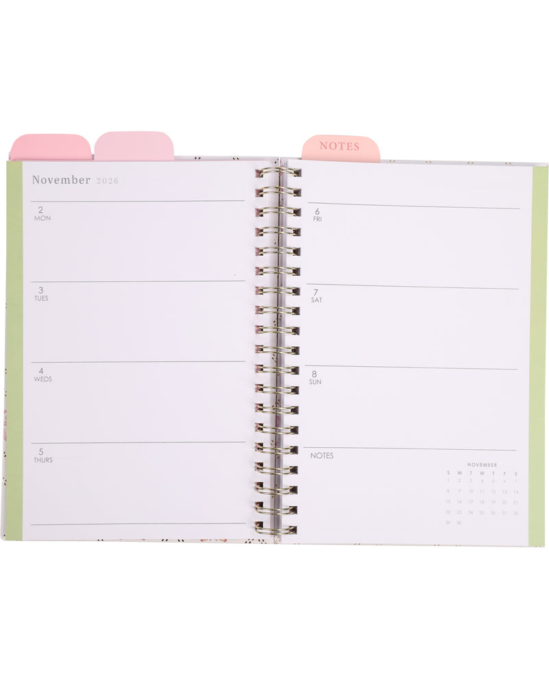 Open planner showing a monthly layout with pink tabs on a white background