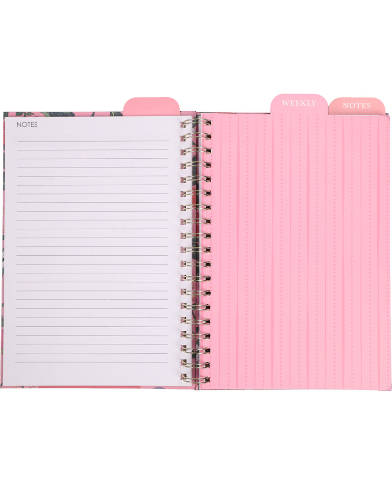 Open notebook with floral cover and pink interior pages on a white background