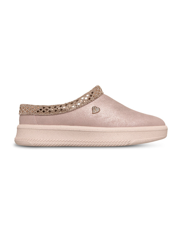 Pink slip-on shoe with decorative strap on a white background