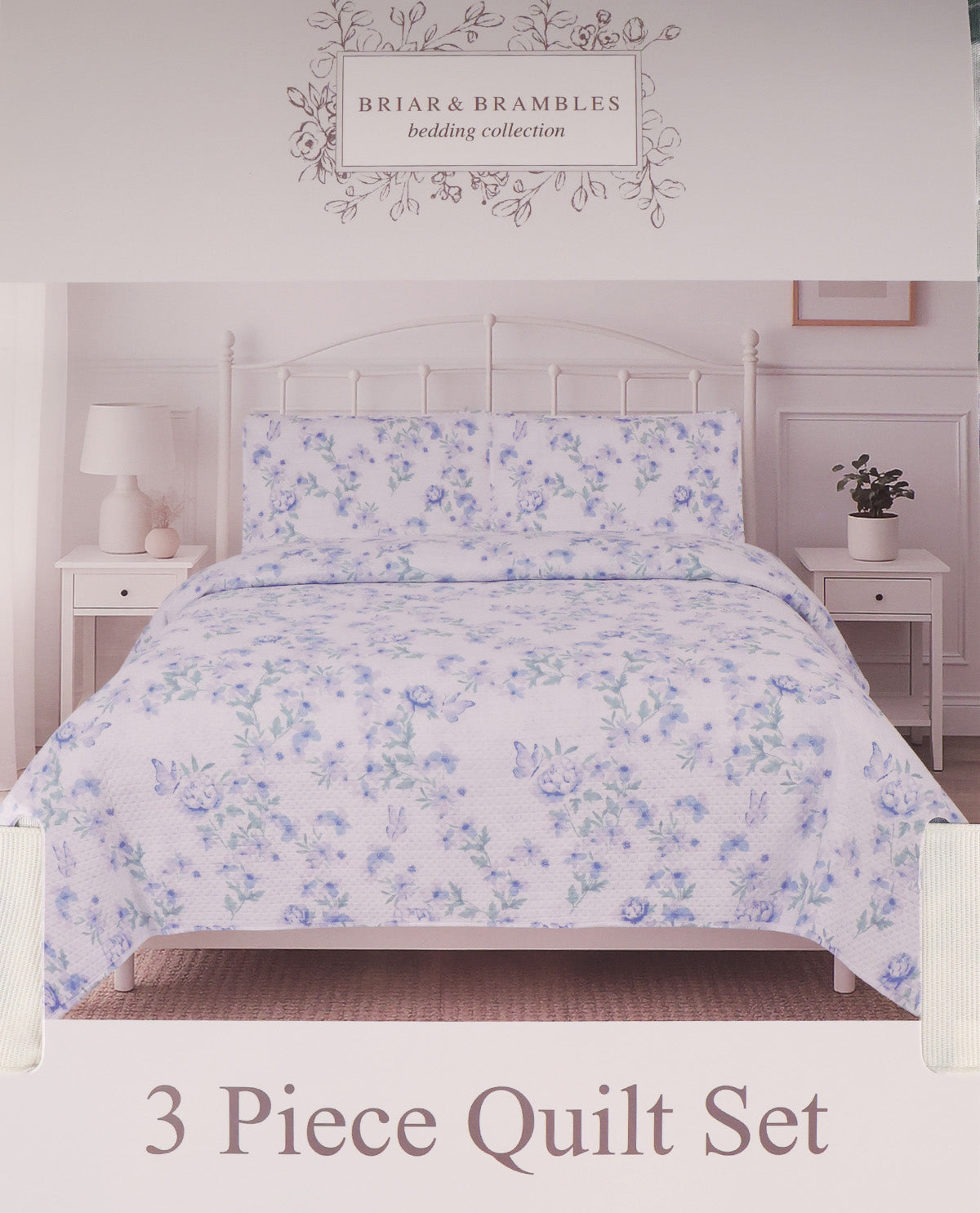A 3-piece quilt set from Briar & Brambles bedding collection, featuring a light lavender and blue floral pattern on a white background, styled on a bed with a white metal headboard.