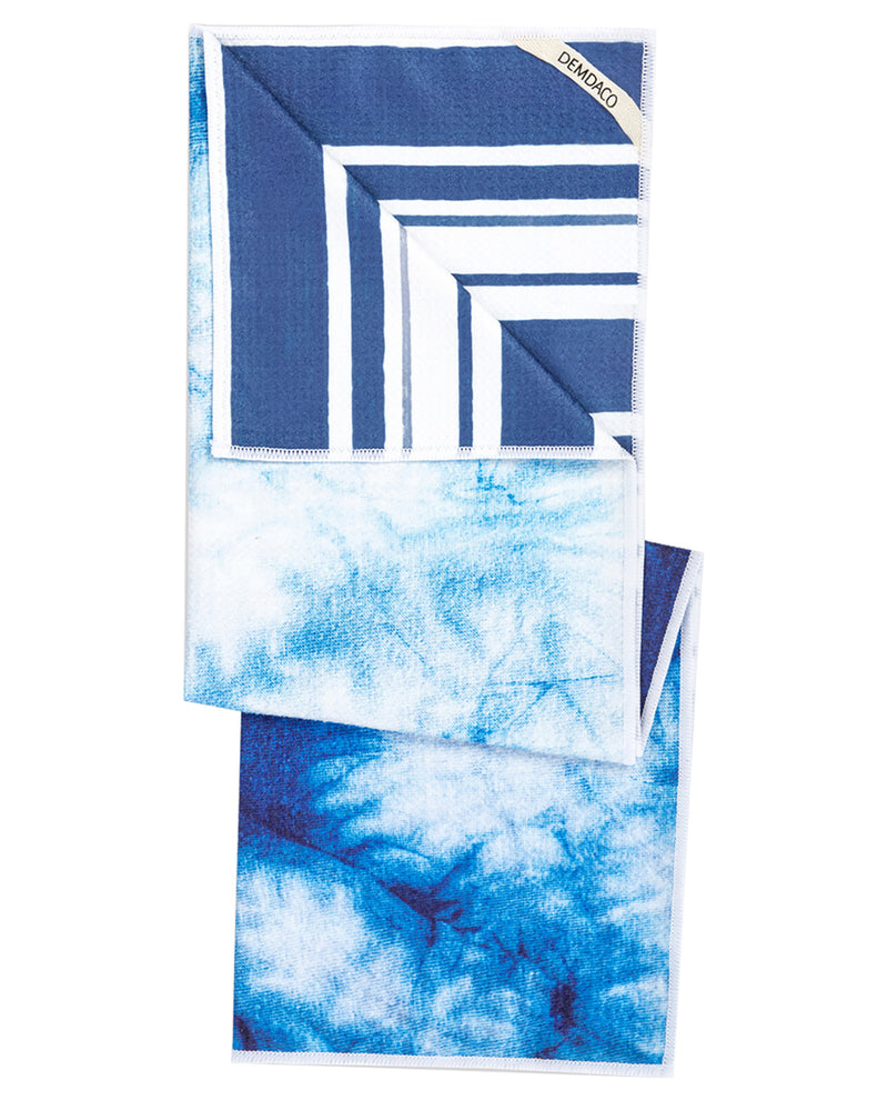 A folded fabric accessory, likely a scarf or pocket square, featuring a blue and white geometric pattern on one side and a blue and white tie-dye pattern on the other, shown against a plain white background.