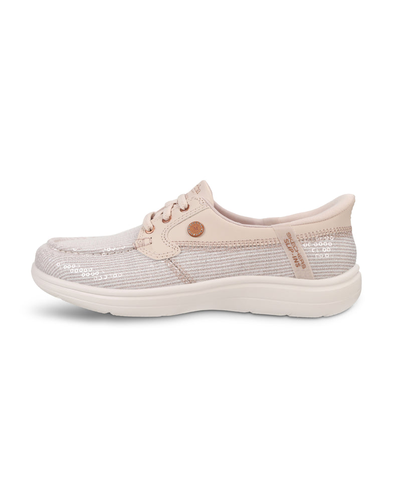 A single women's slip-on shoe in a light blush pink color, featuring a textured knit upper, matching pink laces, a small round metallic button, and a thick white sole, shown against a plain white background.