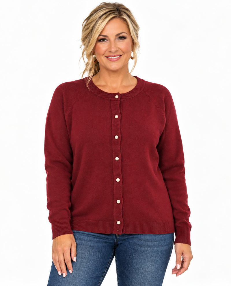 A woman modeling a burgundy button-up cardigan sweater with white buttons, paired with blue jeans, against a plain white background.