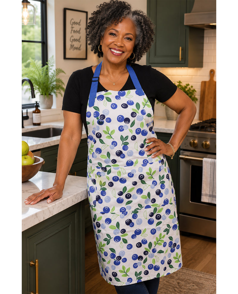 Woman wearing a blueberry patterned apron in a kitchen.