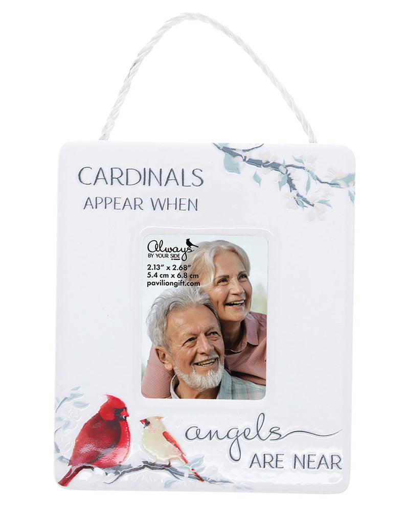 A hanging white decorative sign with a printed photo slot showing a smiling couple, surrounded by cardinal bird illustrations and the text 'CARDINALS APPEAR WHEN angels ARE NEAR.'.
